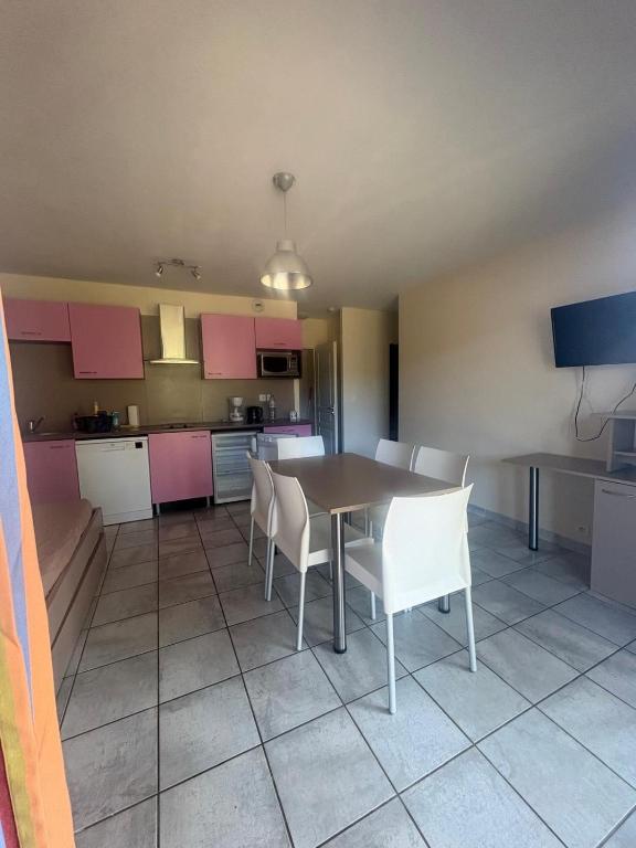 a kitchen with a table and chairs in a room at Chalet gris 4 in Chaveignes