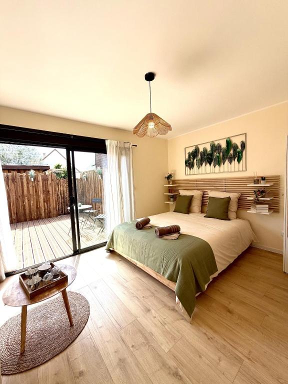 a bedroom with a large bed and a table at Le Cocon de May entre Terre et Mer a proximité de caen in May-sur-Orne
