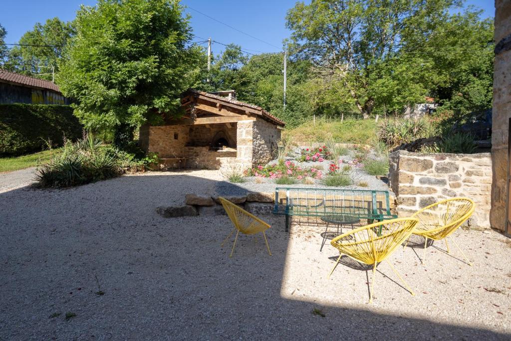 three yellow chairs and a table in a yard at Le refuge à la campagne in Toulonjac