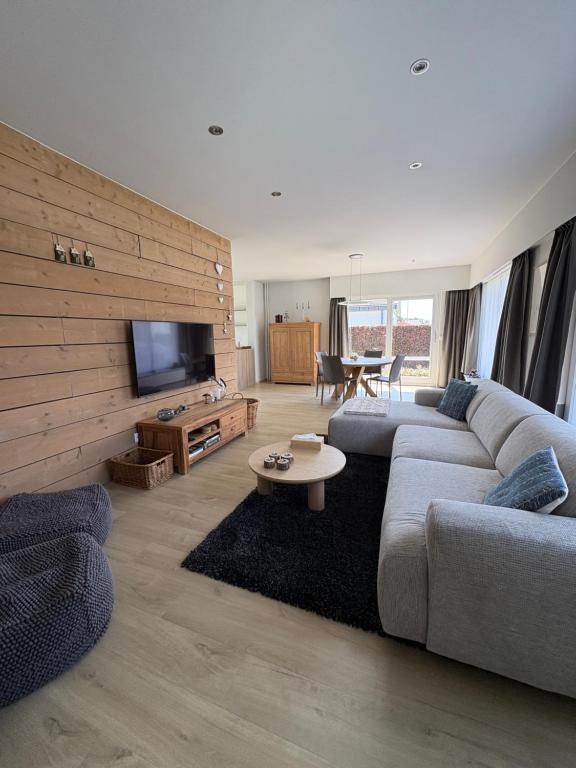 a living room with a couch and a tv at De 50 Steenbrugge in Oostkamp
