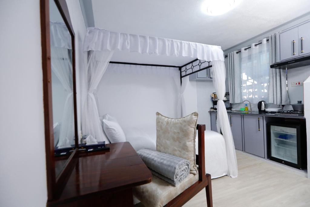 a bedroom with a bed and a desk and a mirror at Self Contained Studio in Nakuru