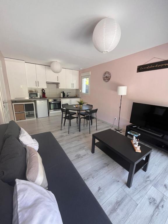 a living room with a couch and a table at Douce Escale, climatisé, 15 min de Strasbourg in Strasbourg