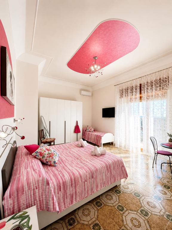 a bedroom with two beds and a large pink ceiling at Il Borgo in Agerola