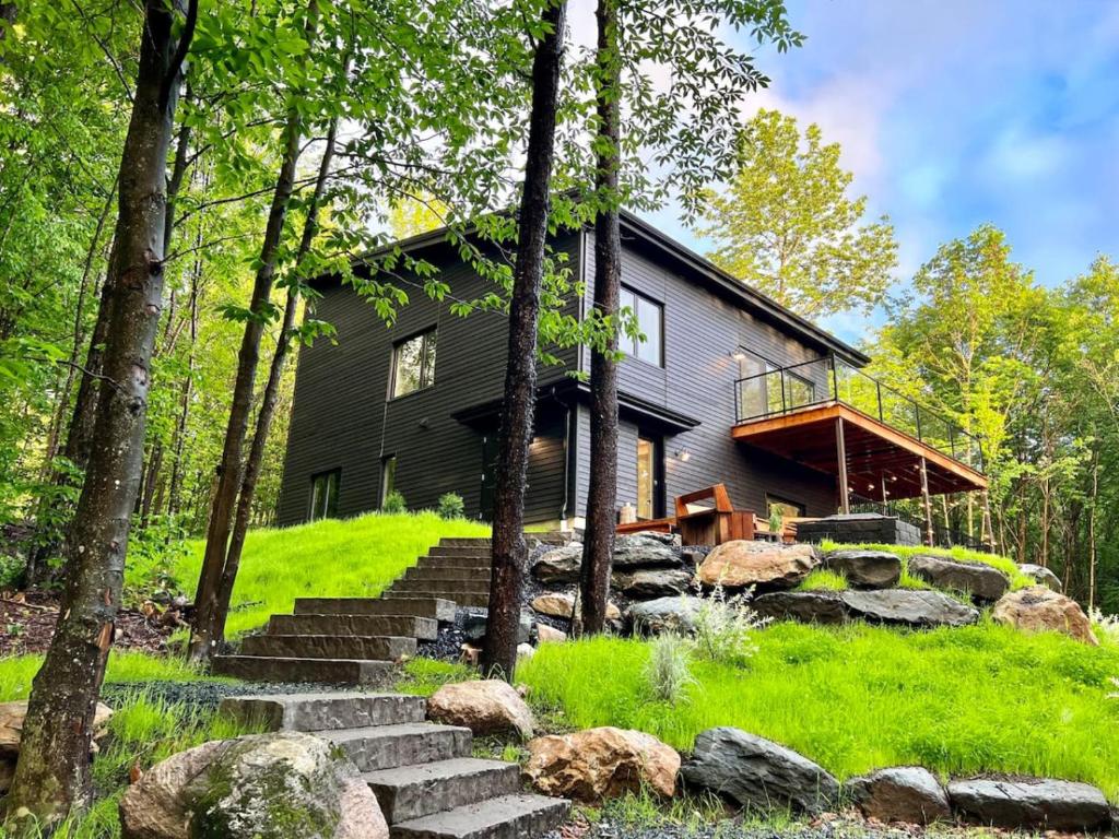 a house in the woods with stairs leading up to it at Pur Nature et Spa Eastman in Eastman