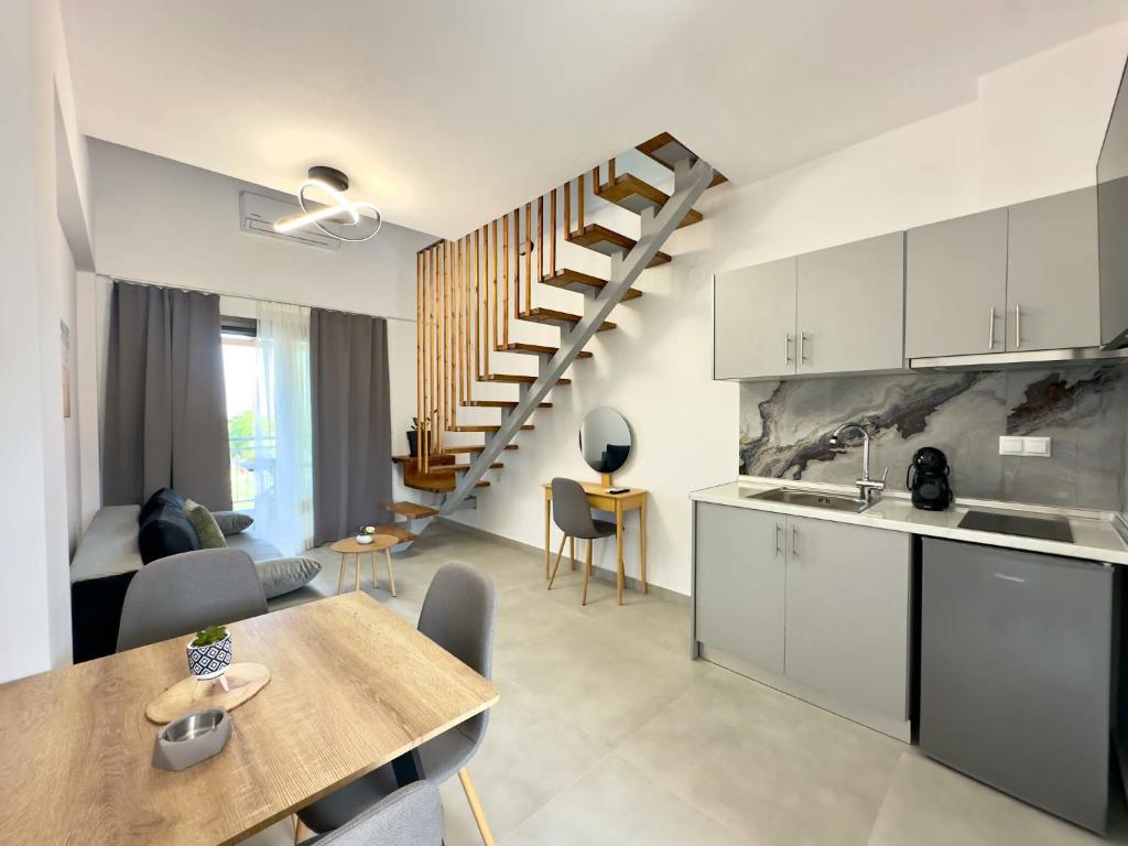 a kitchen and a living room with a staircase at Mimoza Apartments in Limenaria