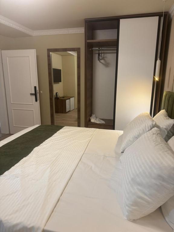 a bed with white sheets and pillows in a room at Premium Rooms in Struga
