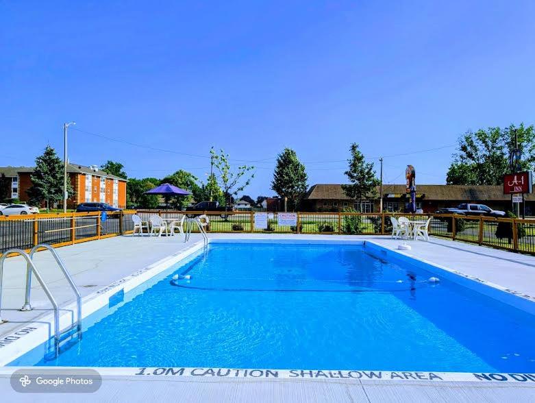 a large blue swimming pool with tables and chairs at A1 Inn Niagara Falls in Niagara Falls