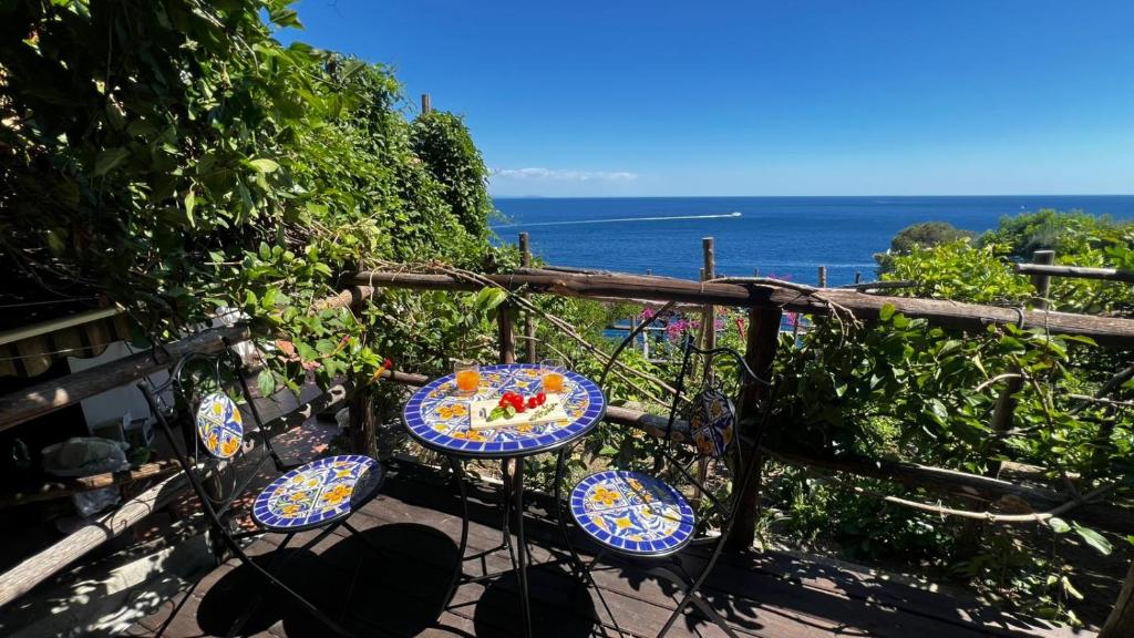 a table and chairs with the ocean in the background at Casa Emi in Amalfi