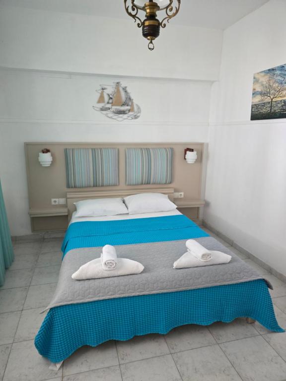a bedroom with a bed with two towels on it at Anna-Maria in Nea Kallikrateia
