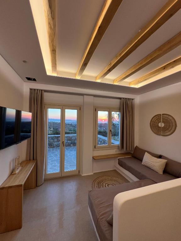 a living room with a couch and windows at Pyrgianos Suites - Private Plunge Pool in Naxos Chora