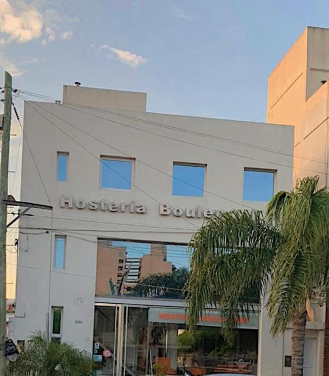 a white building with a sign on the front of it at Hostería Boulevard in Villa María
