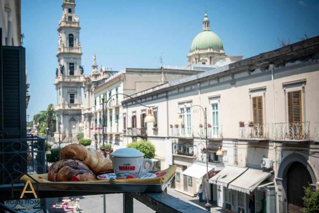 a tray of bread and coffee on a table on a balcony at Roan home Pompei in Pompei