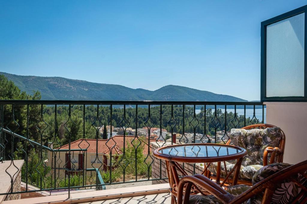 a balcony with a table and chairs and mountains at Casa Panorama in Igoumenitsa
