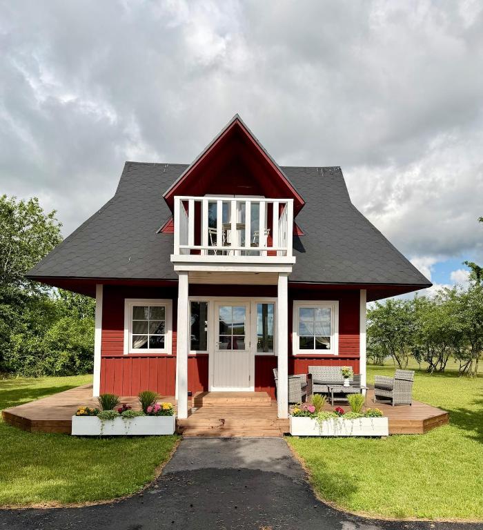 a red house with a gambrel roof at Orjaku Sadamavaade in Orjaku