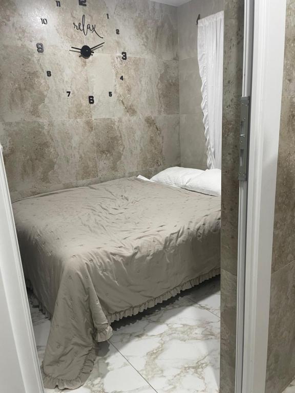 a bedroom with a bed and a clock on the wall at AmurRelaxCreative in Khmelnytskyi