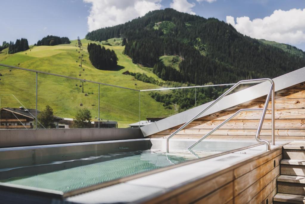 a hot tub with a view of a mountain at Hotel Hasenauer 4 Sterne Superior in Saalbach-Hinterglemm