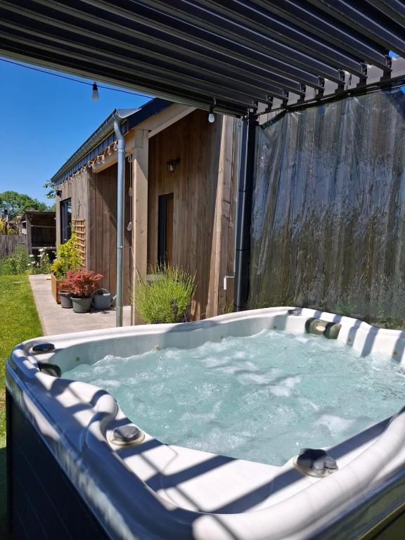 a hot tub in the backyard of a house at Chalet charme et bien-être Jacuzzi et nature près de Durbuy in Durbuy