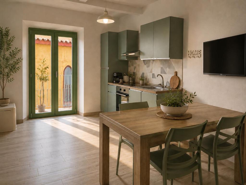 a kitchen with a wooden table and green cabinets at Raggio di Sole Ulassai in Ulassai