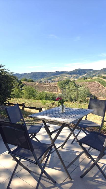 a picnic table and two chairs on a patio at L'orée du vignoble in Vaux-en-Beaujolais