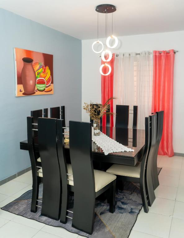 a dining room with a black table and chairs at 3 dormitorios y confortable apartamento in Santo Domingo