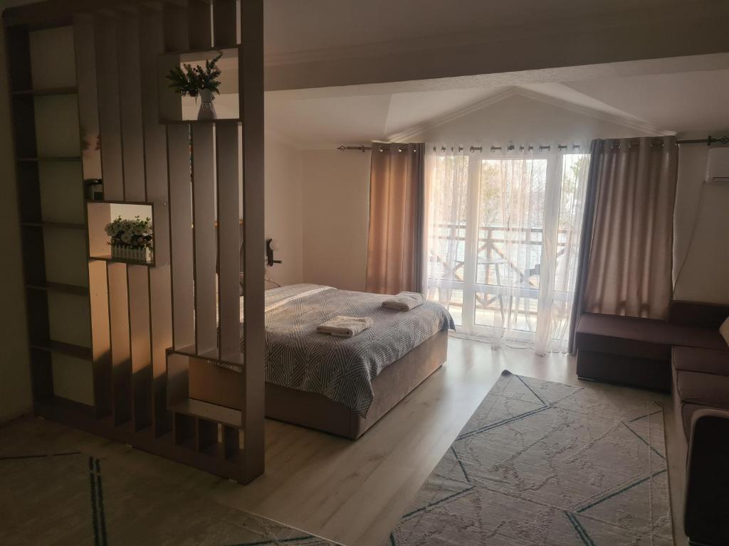 a bedroom with a bed and a large window at Diona Raduga West in Koshkolʼ