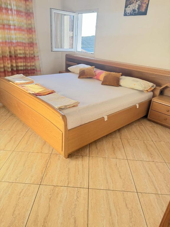 a large bed in a room with a wooden floor at One floor of house in Bar
