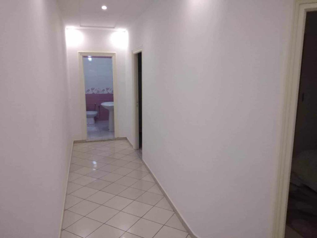 a hallway with a white wall and a room with a bathroom at Appartement Ezzdine sfaxi in Kelibia