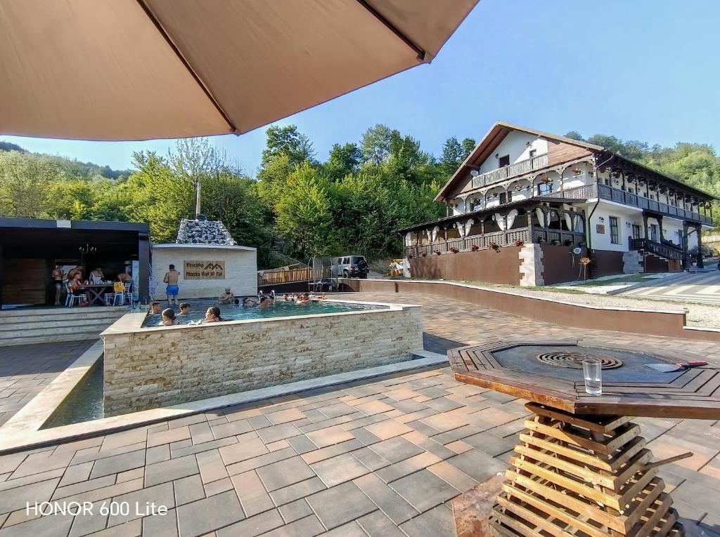 a patio with a hot tub in front of a building at Mosia Dar In Rai in Berbeşti