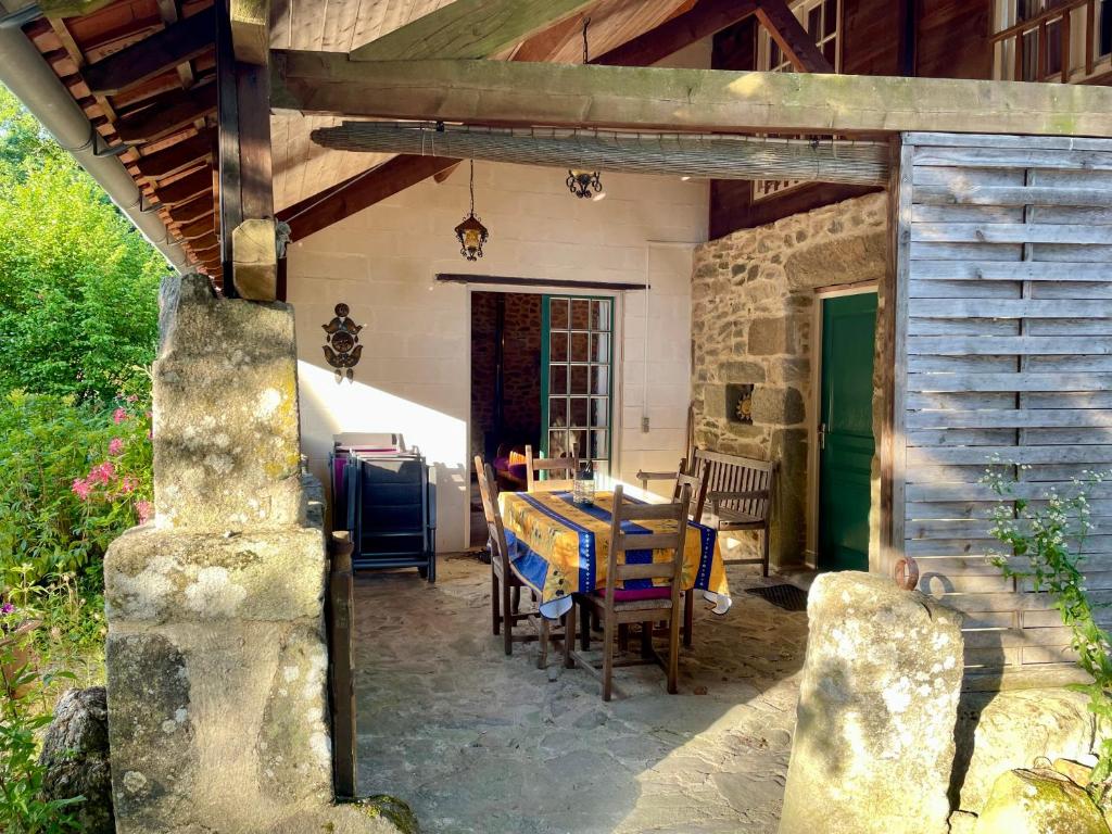 a patio with a table and chairs in a house at La Porcherie in Lacam-dʼOurcet