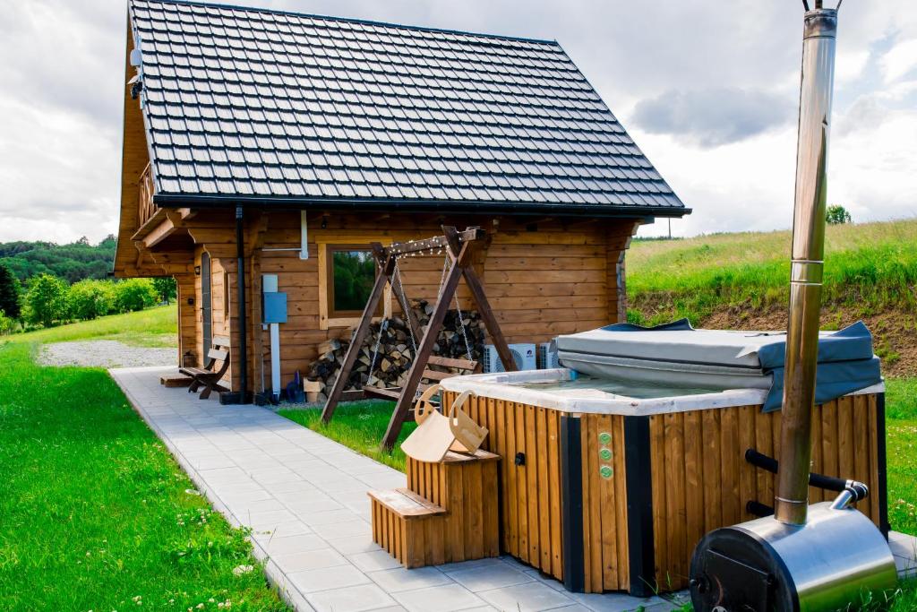 a small wooden cabin with a roof on top of it at Domek na Bieszczadach Domek na Bani 2 in Łukowe