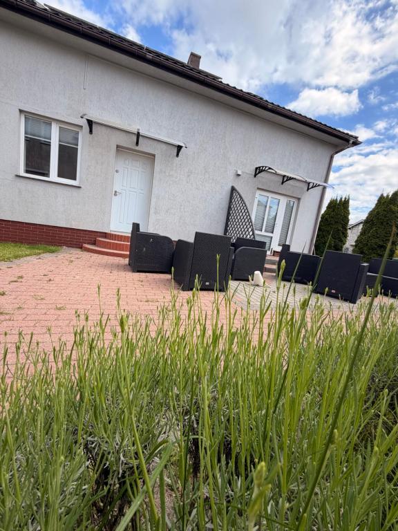 a group of chairs in front of a house at Słoneczne Ranczo Rowy in Rowy