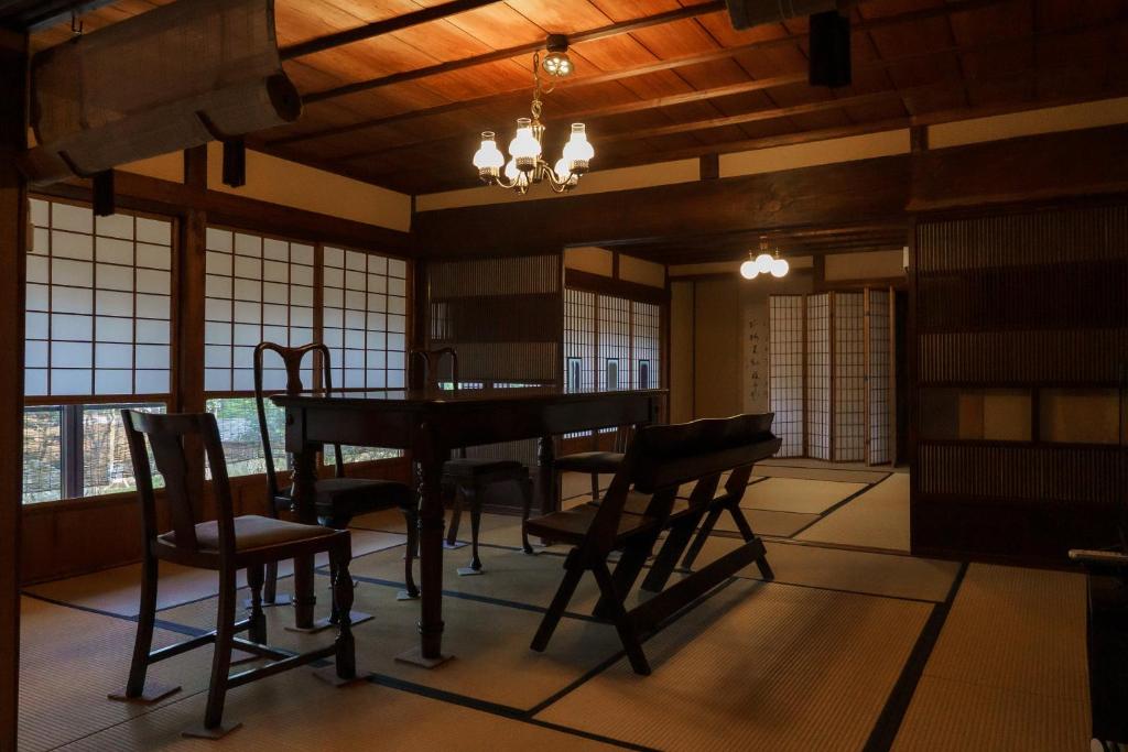 a room with a table and chairs and windows at Tokyo Sake House in Ome