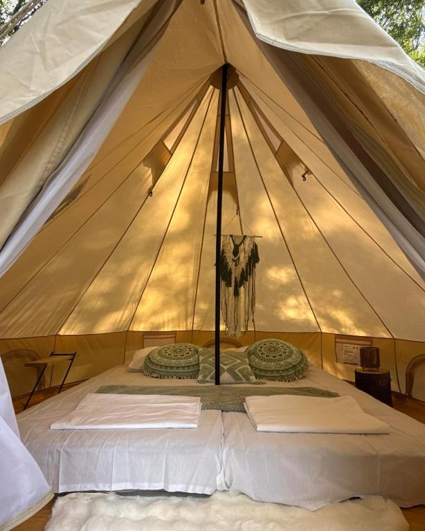 a tent with a bed in the middle at Divlji Mir in Dobro Polje