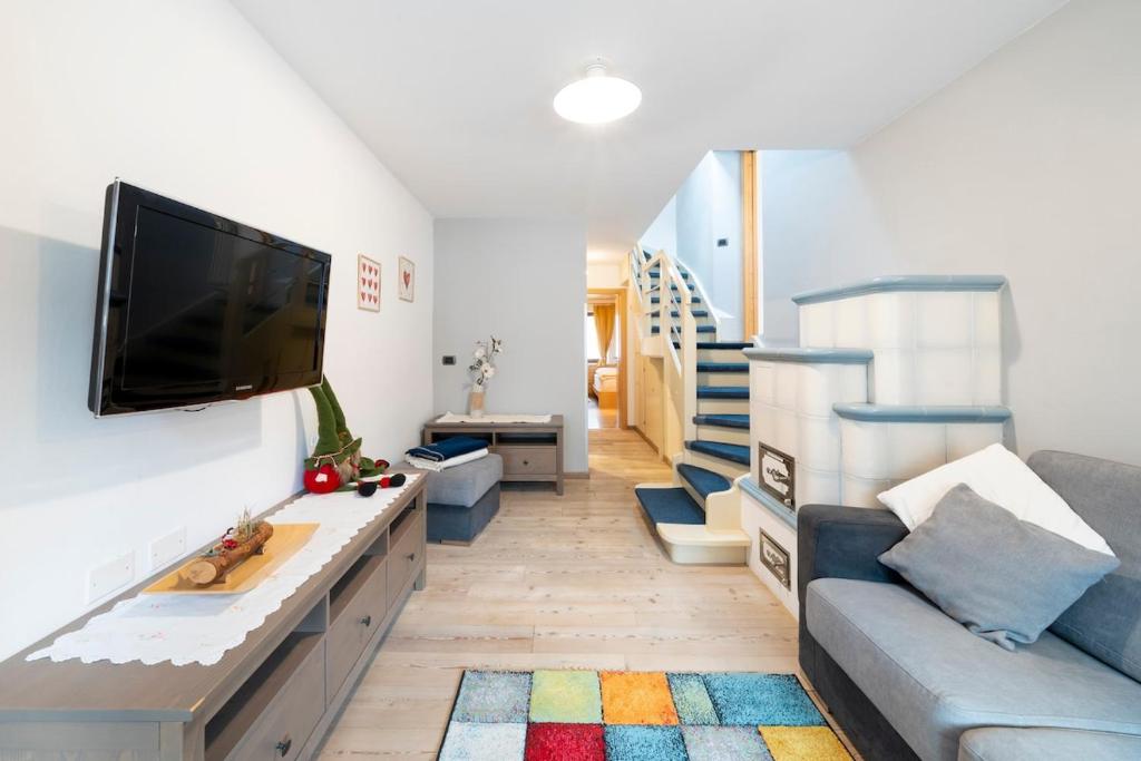 a living room with a couch and a flat screen tv at Césa Marta in Canazei