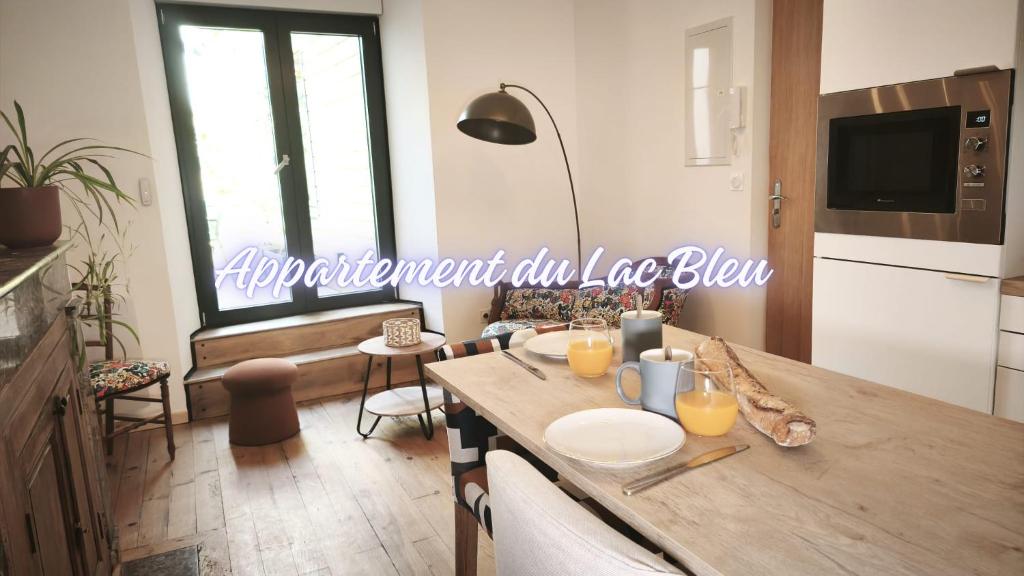 a kitchen with a wooden table with a sign on the wall at La Maison de l'horloge in Bagnères-de-Bigorre