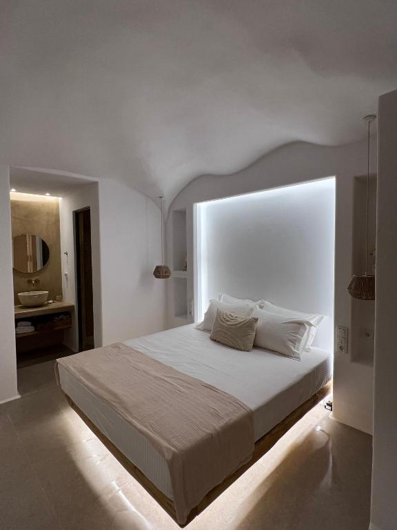 a bedroom with a large white bed with a window at Pyrgianos Suites - Private Jacuzzi in Glinado Naxos