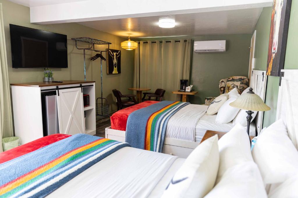 a hotel room with two beds and a television at Lodge at Poncha Springs in Salida