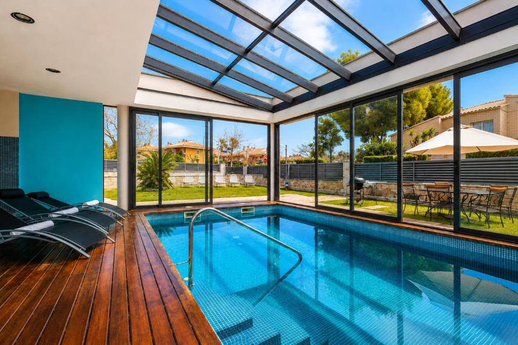 a swimming pool in a house with a glass ceiling at Gira-sol Planetcostadorada in Cambrils
