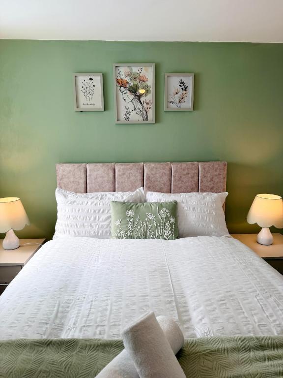 a bedroom with a large white bed with two lamps at Brit Rooms Manchester in Manchester
