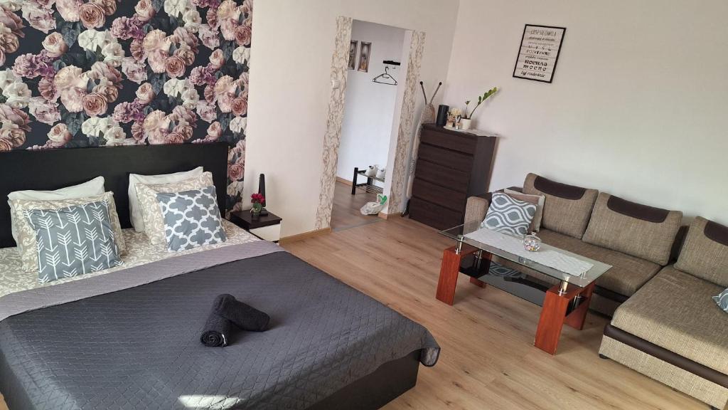 a living room with a bed and a couch at Apartament Kalwaria Piekary in Piekary Śląskie