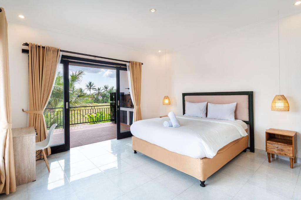 a bedroom with a bed and a balcony at Parafrutts Apartments by Ateliero in Ubud