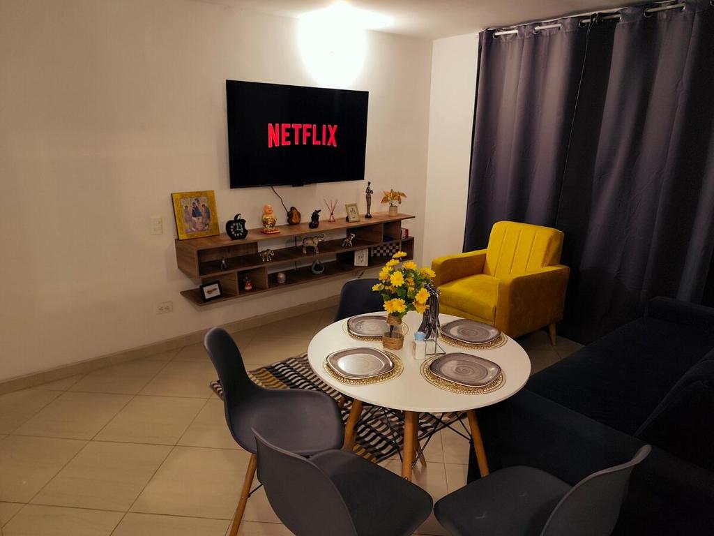 a living room with a table and chairs and a tv at Faro 2 Loft Jaime Duque, Autódromo Tocancipá in Tocancipá