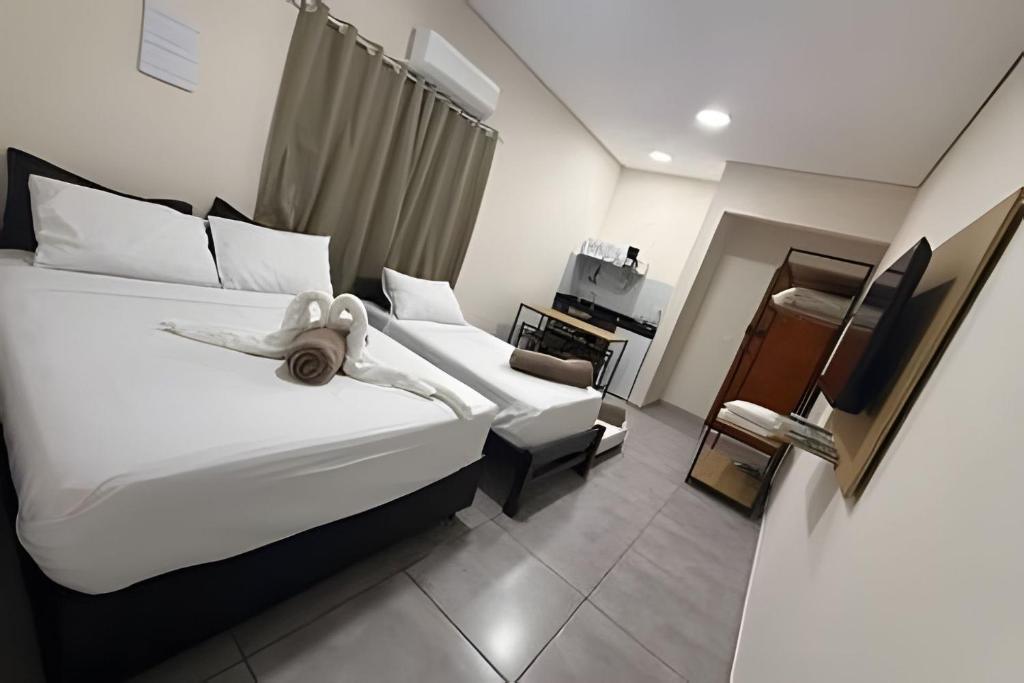 a hotel room with two beds with a doll on it at Estadia Perfeita com AC, Apto a minutos do Aeroporto Gru in Guarulhos