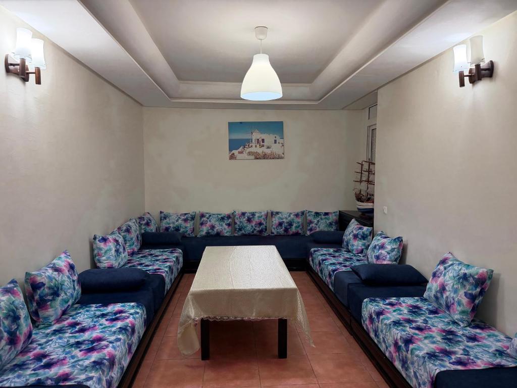 a living room with a couch and a table at Appartement calme avec piscine et proche de la plage in Fnidek