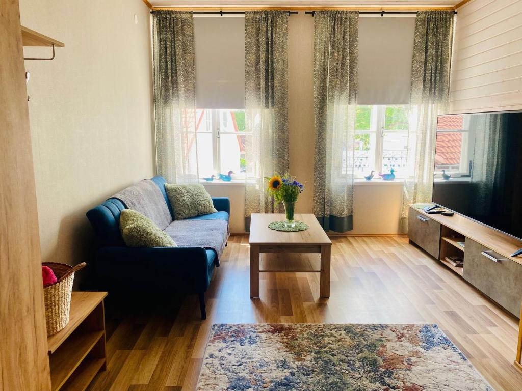 a living room with a blue couch and a table at Kauba 6-6 Apartment in Kuressaare