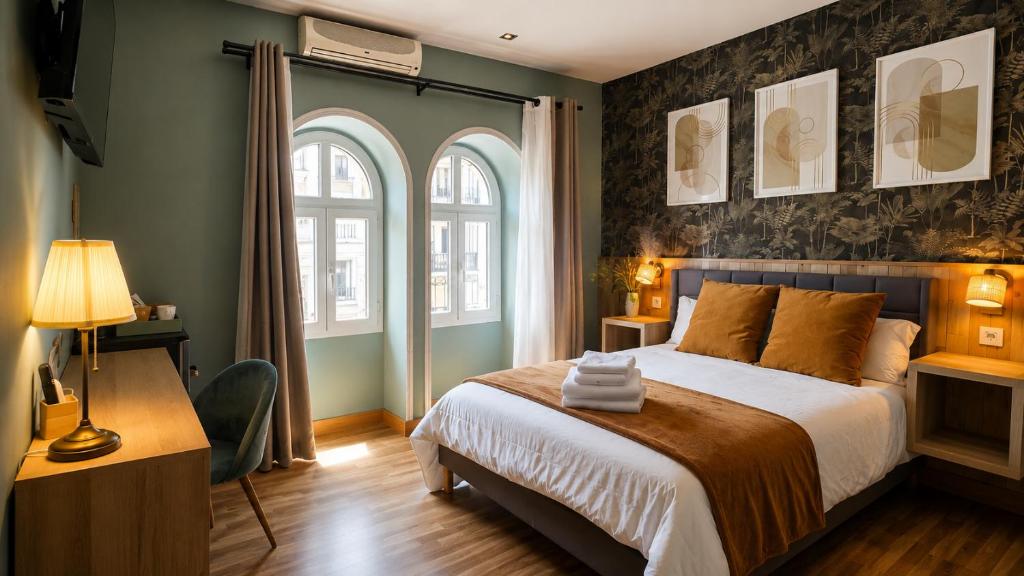 a bedroom with a large bed and two windows at Hostal Luxury Green Madrid Gran Vía in Madrid