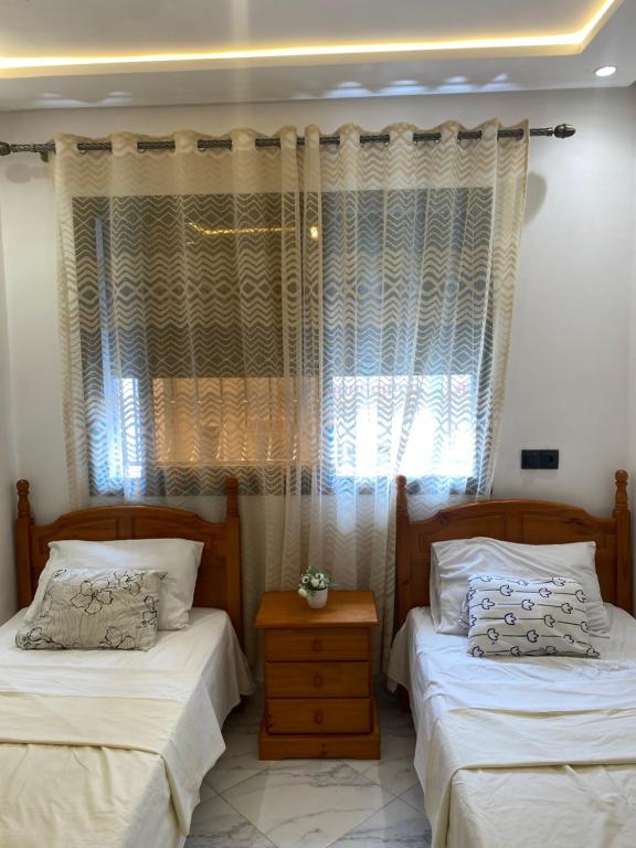 a bedroom with two beds and a window at Appartement 2 chambres Martil in Martil