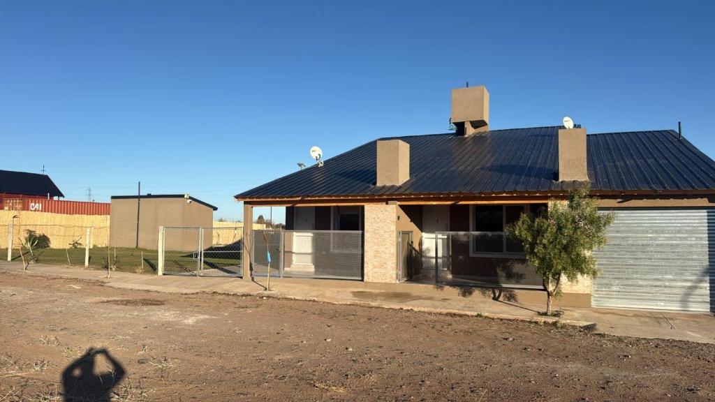 a house with solar panels on top of it at Duplex 1 en villa el chocon LO DE CARLITOS in Villa El Chocón