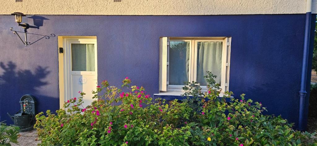 a blue house with a white door and windows at le Studio Balnéo des Cocons de Mel in Quinssaines
