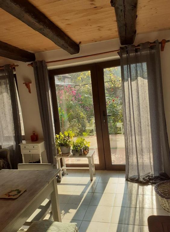 a living room with a large window and a table at Casa Luna Betiluna in Ciclova-Montană